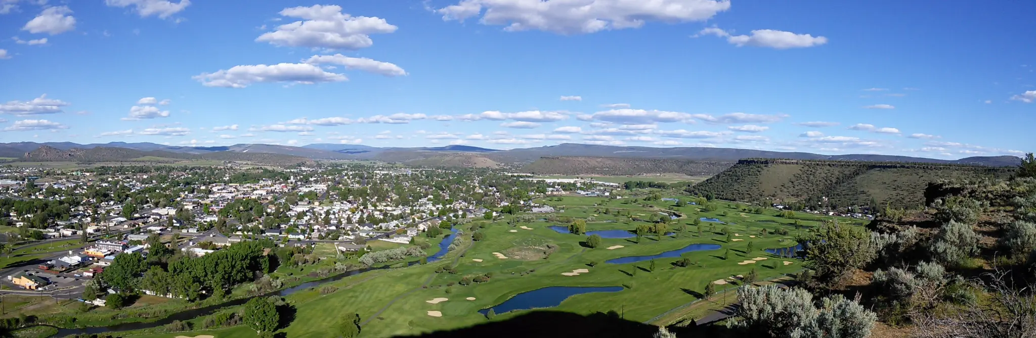 Aerial panoramic view of Prineville, Oregon with the Crooked River golf course and Cascade Mountains