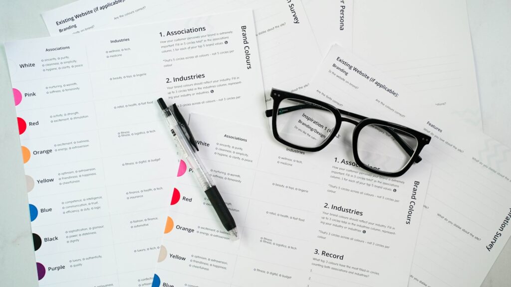 a pair of glasses sitting on top of a pile of paper